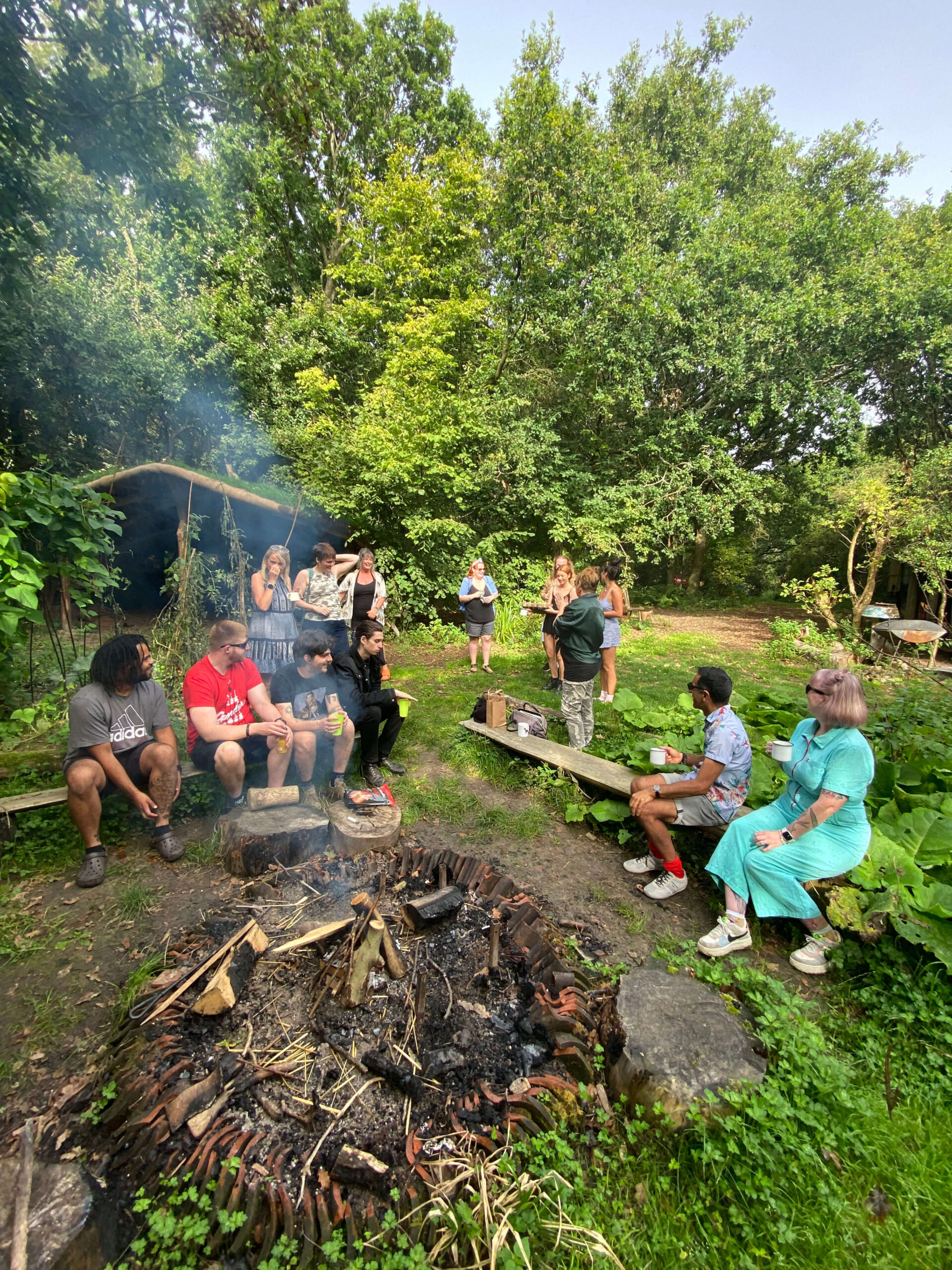 A group of people sitting around a campfire in the woods